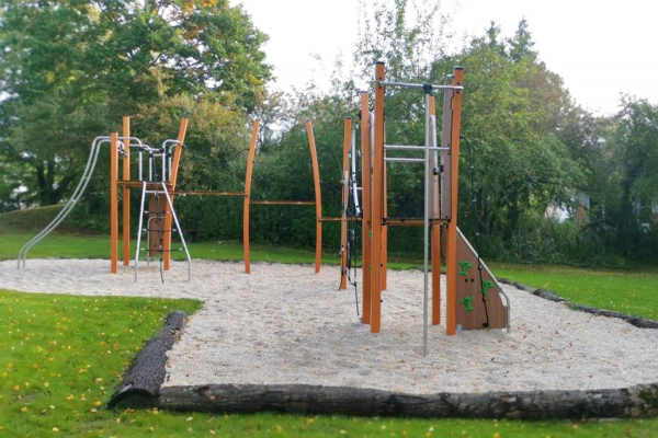 Spielplatz in Annerod mit moderner Kletter- und Rutschenanlage aus Holz und Edelstahl auf Fallschutzkies, umgeben von Grünflächen.