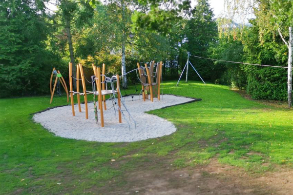 Spielplatz in Annerod mit Kletterlandschaft, Balancierseilen und Seilbahn, eingebettet in eine grüne Umgebung mit Bäumen.