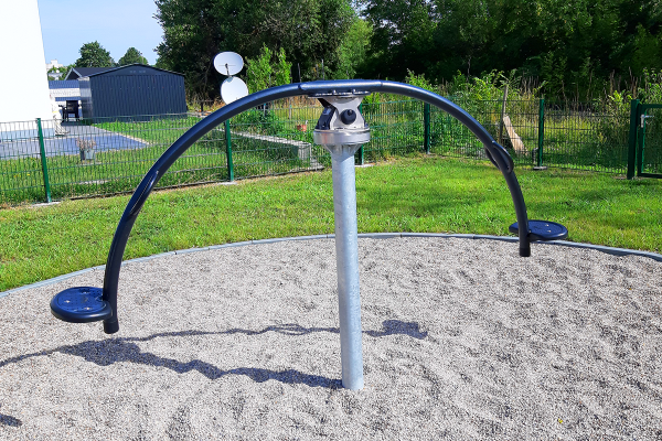 Drehspielgerät „Hip-Hop“ mit zwei runden Trittplatten an gebogenem Stahlgestänge, installiert auf Fallschutzkiesfläche.