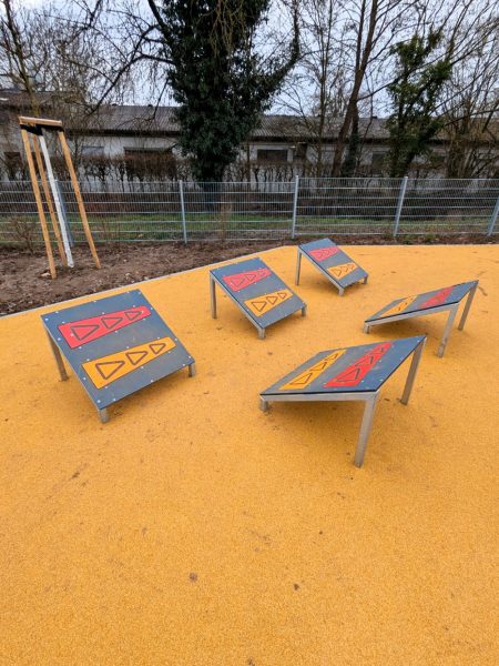 Fünf schräge Sprungplattformen mit farbigen Markierungen auf Fallschutzboden