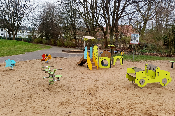 Kleinkinder-Spielbereich mit Federspielgeräten, Spielhaus und Sandfläche auf dem Spielplatz Maiwiese in Herford.