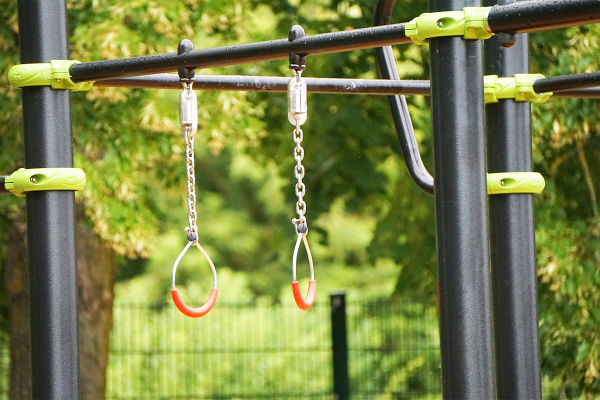 Gymnastikringe an einer inklusiven Calisthenics- und Street-Workout-Anlage mit robusten Stahlstangen im Außenraum