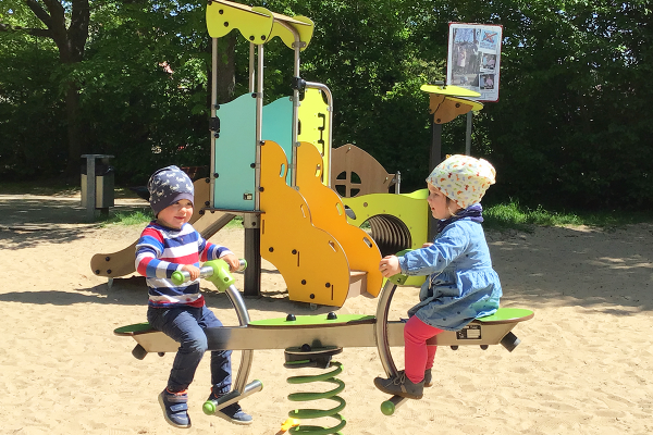 Zwei Kleinkinder spielen gemeinsam auf einem Federspielgerät auf dem Spielplatz Maiwiese in Herford.
