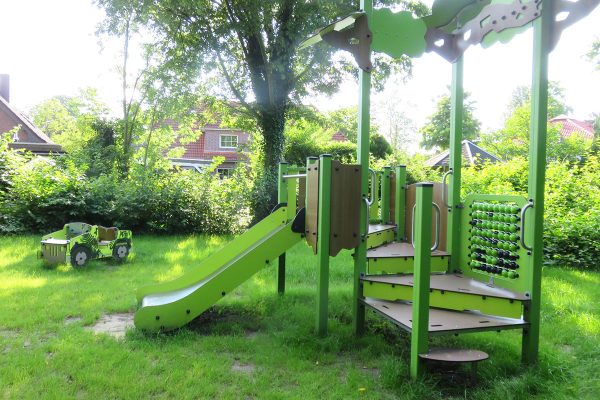 Sensorisch-inklusives Spielgerät mit Rutsche auf dem Spielplatz Dürerstraße in Weyhe, eingebettet in eine naturnahe Grünfläche