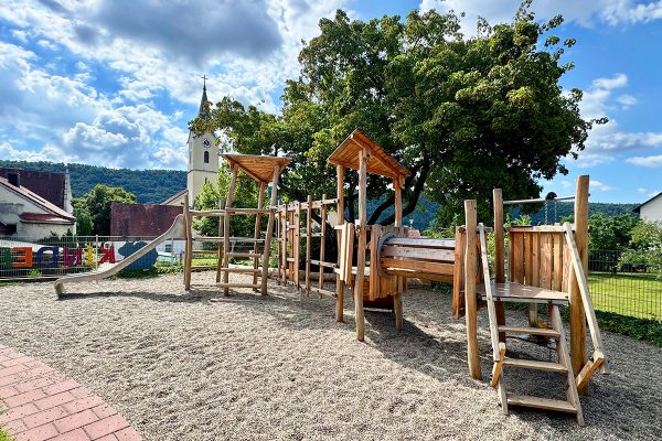 Individuelle Holzspielanlage aus Robinienholz mit Kletterwand, Tunnel, Spielpodesten und Rutsche im Kindergarten St. Bartholomäus in Dietfurt an der Altmühl.